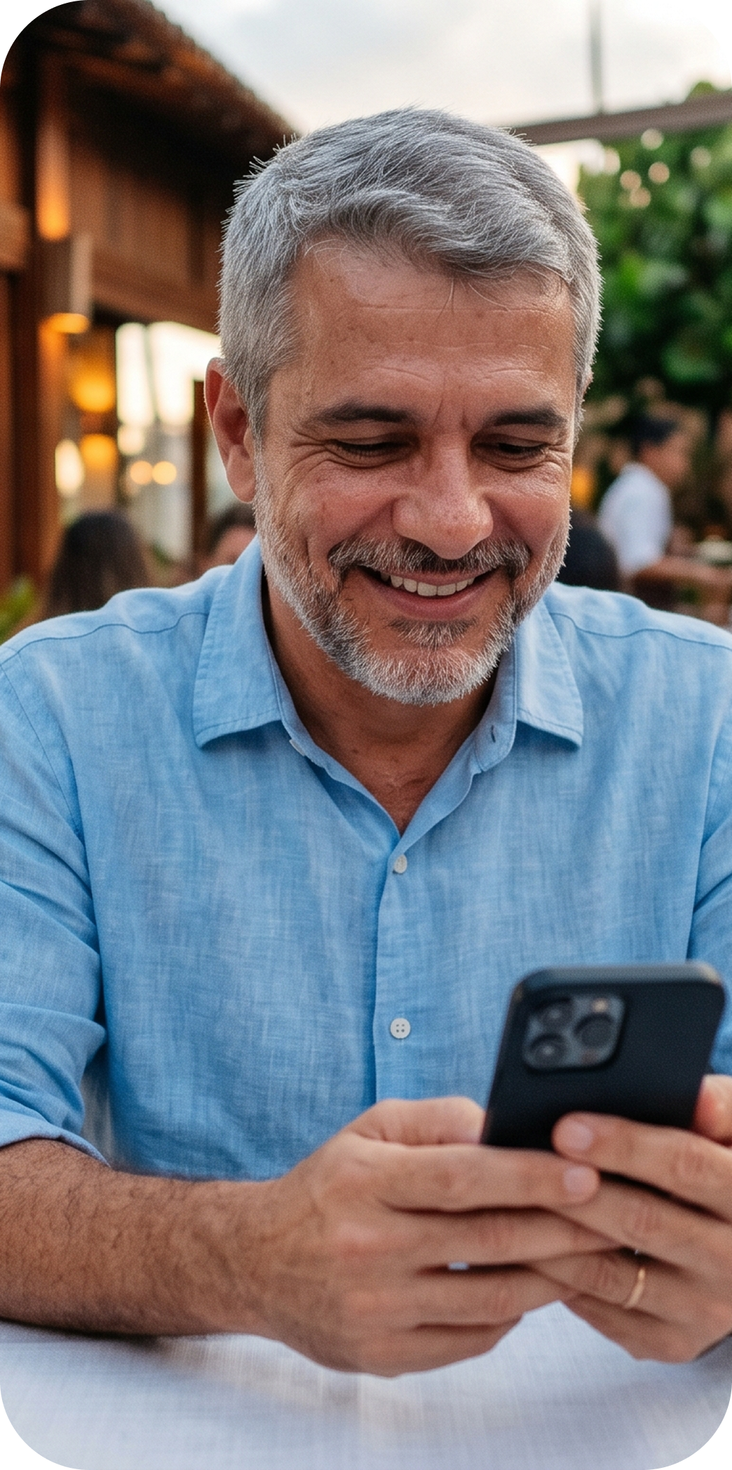 Homem sorrindo usando smartphone em ambiente externo